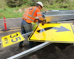 photo showing curve warning signs being installed
