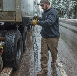 photo of a person putting chains on their semi truck